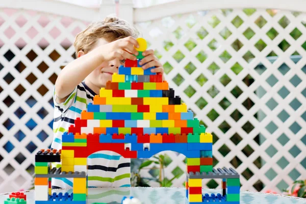 Niño rubio y niño jugando con un montón de bloques de plástico de colores. —  Fotos de Stock