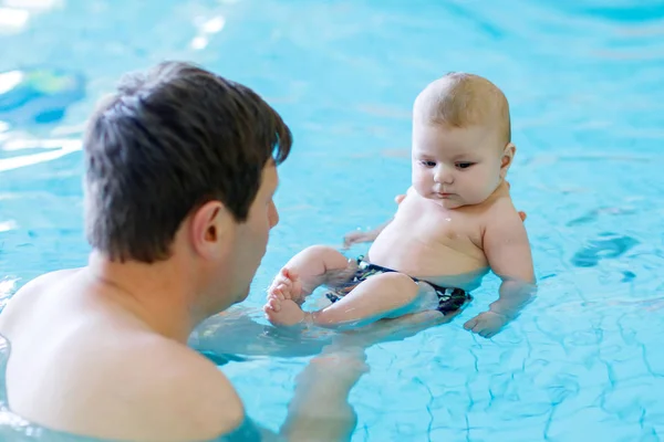 Glücklicher Vater mittleren Alters schwimmt mit niedlichem, entzückendem Baby im Schwimmbad. — Stockfoto