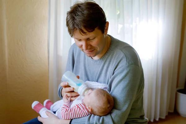 Father feeding newborn baby daughter with milk in nursing bottle — Stock Photo, Image