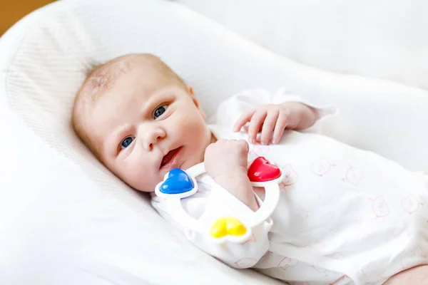 Linda niña jugando con colorido juguete sonajero —  Fotos de Stock