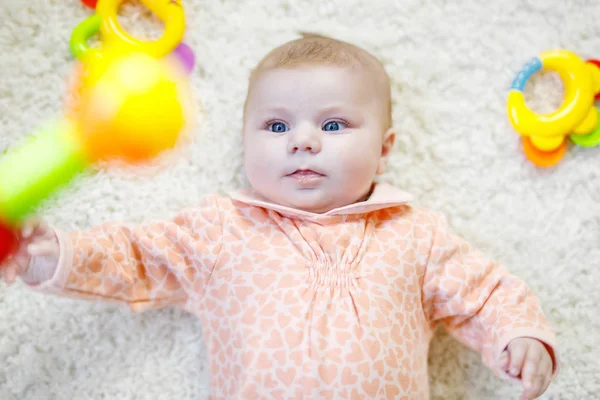Schattig baby meisje spelen met kleurrijke rammelaar speelgoed — Stockfoto