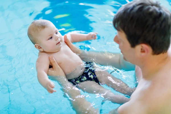 Feliz padre de mediana edad nadando con lindo bebé adorable en la piscina . — Foto de Stock