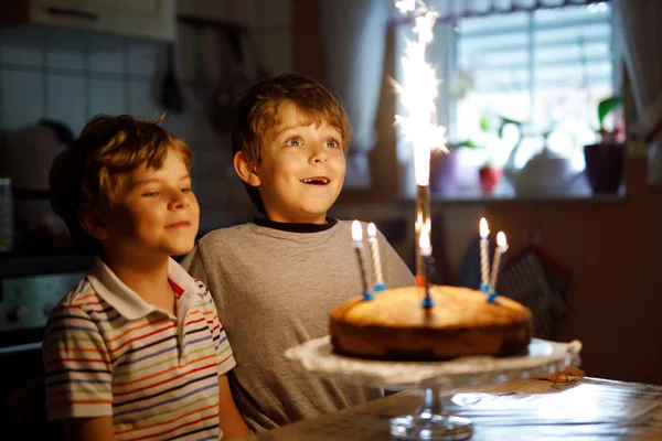 Niños pequeños niños gemelos celebrando cumpleaños y soplando velas en la torta —  Fotos de Stock