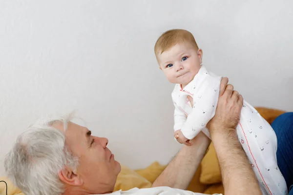 Happy grandfather holding adorable baby girl grandchild on arms. — Stock Photo, Image