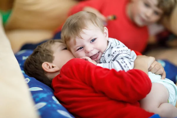 Little kid boy hugging with newborn baby girl, cute sister. Brother on background — Stock Photo, Image