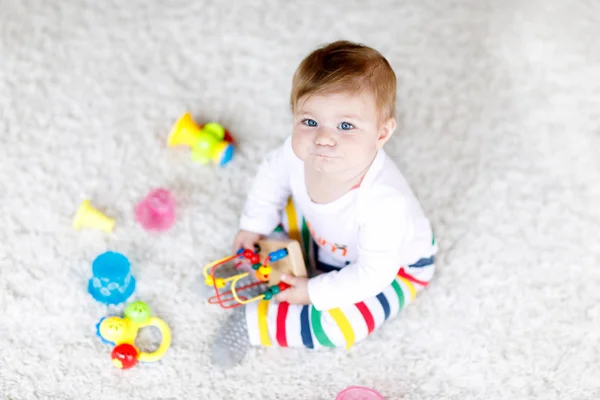 Очаровательная девочка, играющая с образовательными игрушками в детской — стоковое фото