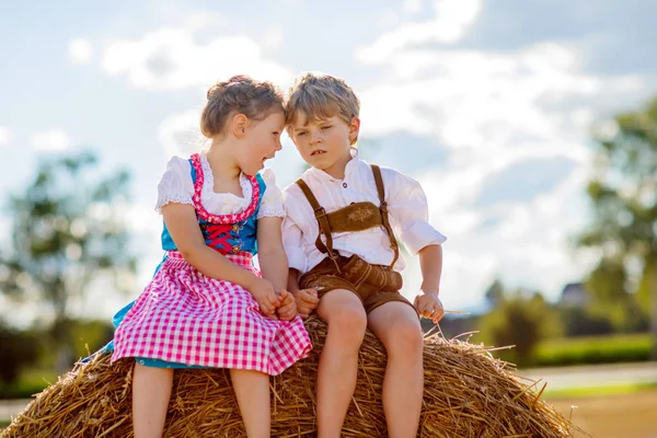 Twee kinderen, jongen en meisje in traditionele Beierse kostuums in tarweveld — Stockfoto