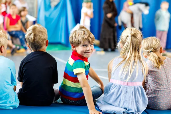 Crianças assistindo teatro ou concerto na escola. Garotinho sorrindo — Fotografia de Stock