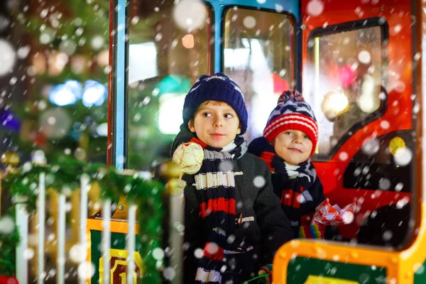 Dos niños pequeños en carrusel en el mercado de Navidad — Foto de Stock