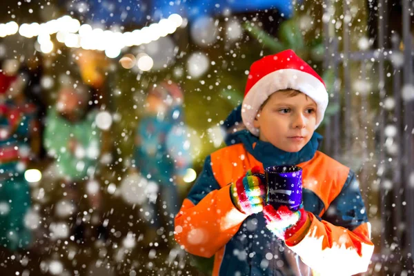 Kleiner Junge mit heißer Schokolade auf dem Weihnachtsmarkt — Stockfoto