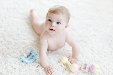 Renkli pastel, eski model çıngıraklı yılanla oynayan tatlı bir kız.