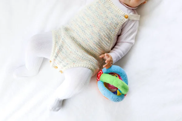Крупный план детского тела и ног с большим количеством красочных игрушек гремучей смеси . — стоковое фото