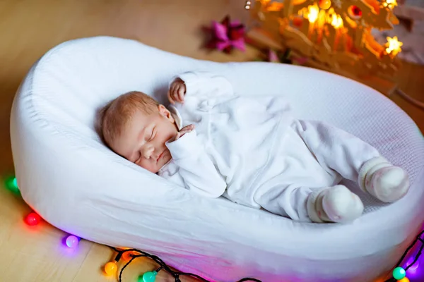 Noel ağacının yanında uyuyan bir hafta eski yeni doğan bebek kız — Stok fotoğraf