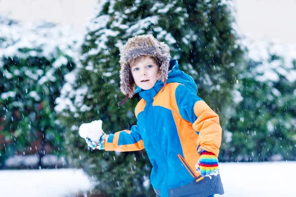 Gelukkig kid jongen hebben plezier met sneeuw in de winter — Stockfoto