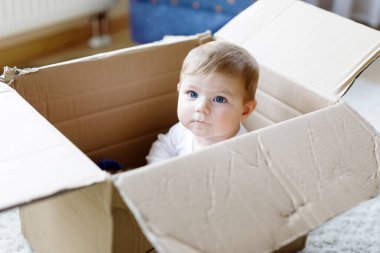 Bir posta kutusunda oturan bebek kız. Mavi gözlü şirin bebek