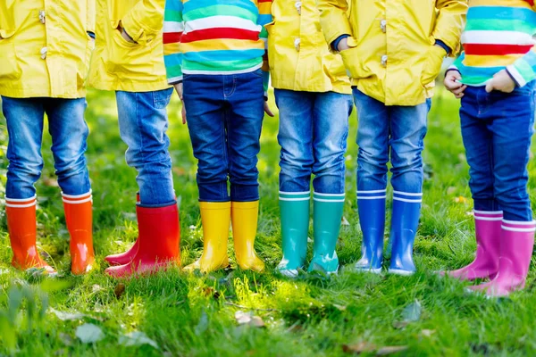 Little kids, boys or girls in jeans and yellow jacket in colorful rain boots — Stock Photo, Image