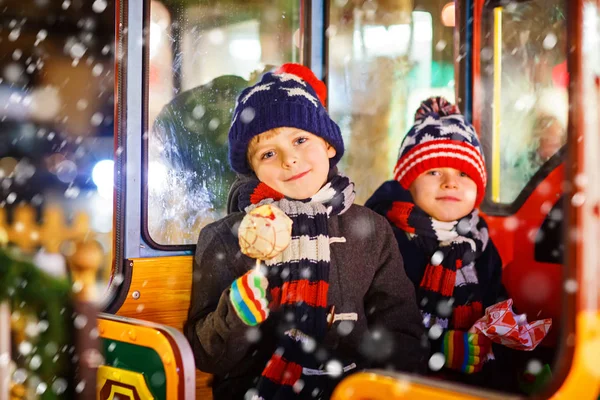 Dwa małe dzieci chłopców na karuzeli na Jarmark bożonarodzeniowy — Zdjęcie stockowe