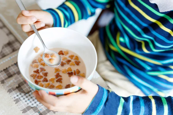 Закрытие рук мальчика, поедающего домашние хлопья на завтрак или обед — стоковое фото