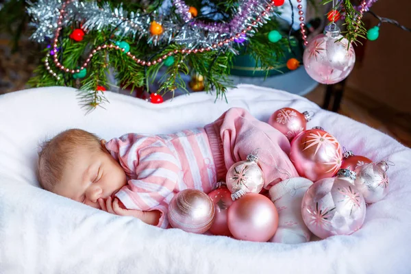 Неделя новорожденная девочка с розовыми шариками возле елки — стоковое фото