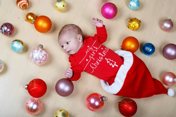 Newborn baby with Christmas tree decoarations and colorful toys and balls — Stock Photo, Image