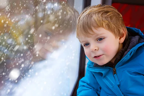 Niedliches kleines Kleinkind, das aus dem Zugfenster schaut — Stockfoto