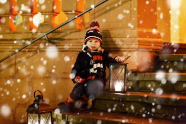 Kilisenin yanındaki merdivenlerde feneri olan sevimli bir çocuk..