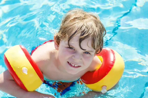 Glad liten unge pojke ha kul i en pool — Stockfoto