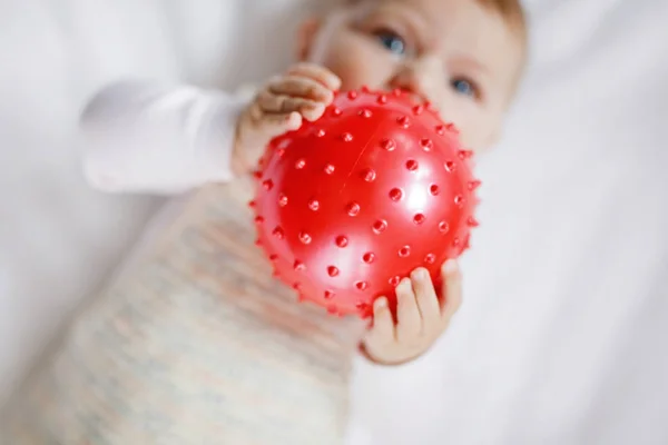 Cute baby playing with red gum ball, crawling, grabbing — Stock Photo, Image