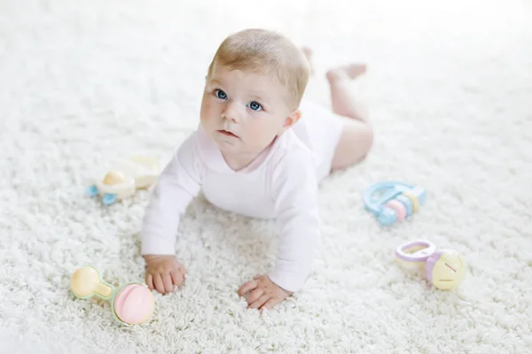 Schattig baby meisje spelen met kleurrijke pastel vintage rammelaar speelgoed — Stockfoto