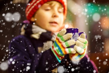 Küçük çocuk çocuk Noel piyasada sıcak çikolata içme