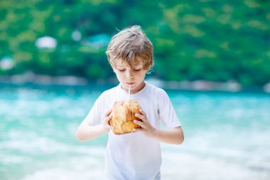 Hindistan cevizi suyu içme tropik sahilde küçük çocuk çocuk