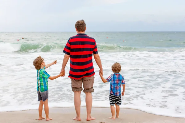 Twee kleine kids jongens en vader op het strand van de Oceaan — Stockfoto