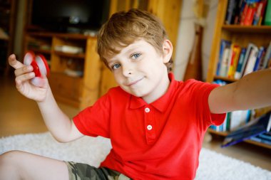 Tri kıpır el Spinner ile kapalı oynayan okul çocuk