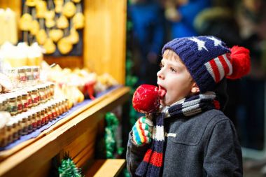 Küçük çocuk çocuk beslenme şeker elma tatlı Noel pazarı üzerinde durmak