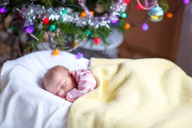 Noel ağacının yanında uyuyan bir hafta eski yeni doğan bebek kız