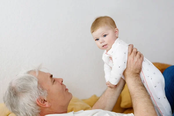 Happy dědeček hospodářství rozkošné dítě dívka vnouče na zbraně. — Stock fotografie