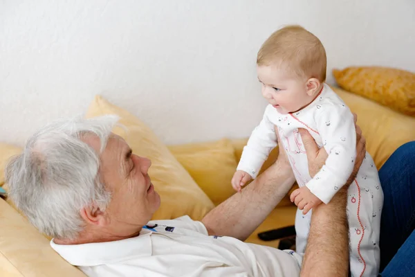 Happy grandfather holding adorable baby girl grandchild on arms. — Stock Photo, Image
