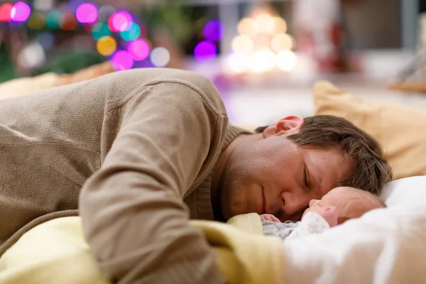 Pai de meia-idade dormindo perto de sua filha recém-nascida no Natal — Fotografia de Stock