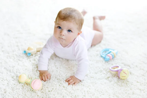 Schattig baby meisje spelen met kleurrijke pastel vintage rammelaar speelgoed — Stockfoto