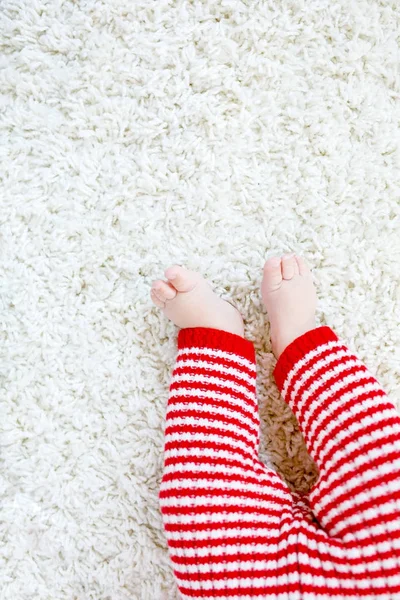 Close-up of baby body and legs in red Santa Clause trousers on Christmas — Stock Photo, Image