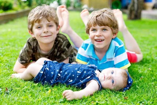 Two little happy kid boys with newborn baby girl, cute sister. — Stock Photo, Image