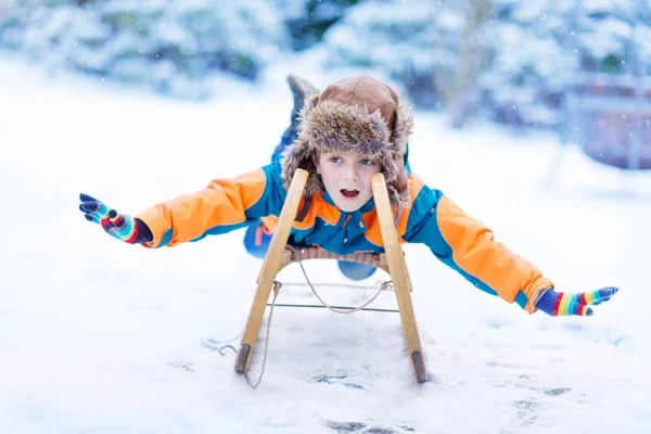 Kis gyerek fiú élvezi téli szánkózás — Stock Fotó