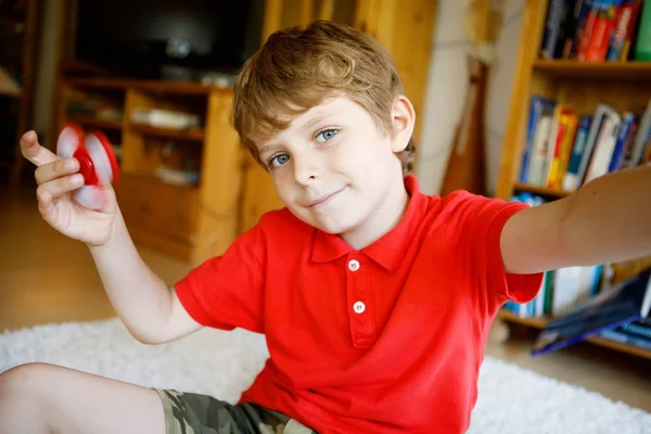 Menino da escola brincando com Tri Fidget Hand Spinner dentro de casa — Fotografia de Stock