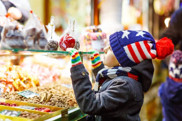 ジンジャーブレッドとお菓子と子供男の子がクリスマス マーケットの上に立つ — ストック写真
