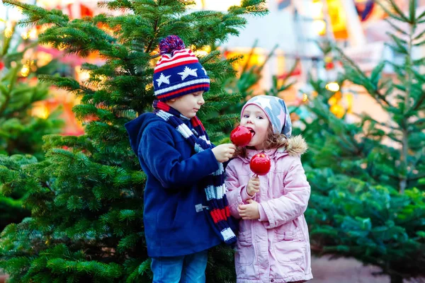 Deux petits enfants mangeant de la pomme à sucre sur le marché de Noël — Photo