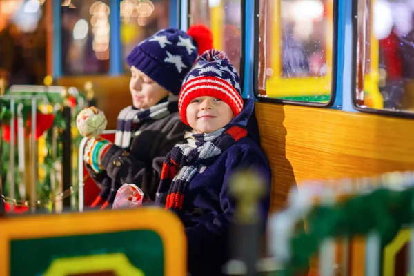 Dois meninos pequenos no carrossel no mercado de Natal — Fotografia de Stock