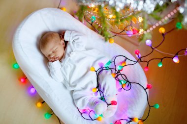 Noel ağacının yanında uyuyan bir hafta eski yeni doğan bebek kız