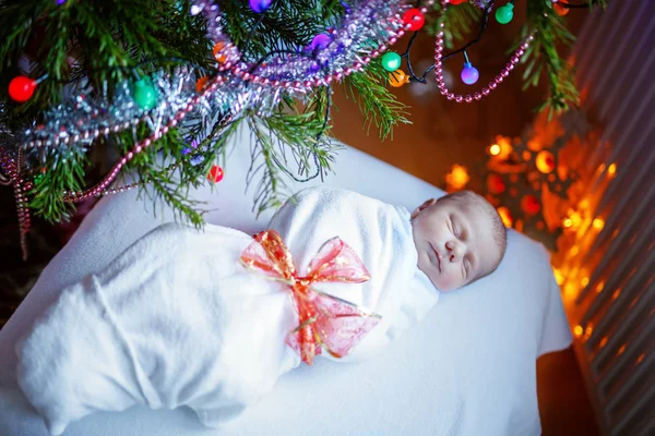 Een week oud pasgeboren baby gewikkeld in een deken in de buurt van de kerstboom — Stockfoto