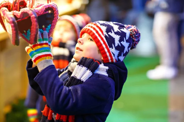 Piccolo ragazzo carino comprare dolci da uno stand cancy sul mercato di Natale — Foto Stock