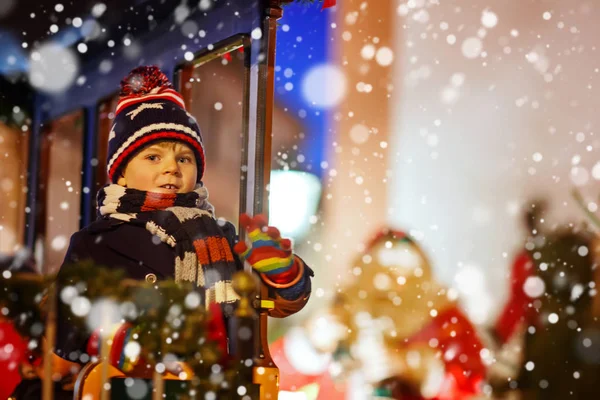 Niño pequeño en carrusel en el mercado de Navidad — Foto de Stock